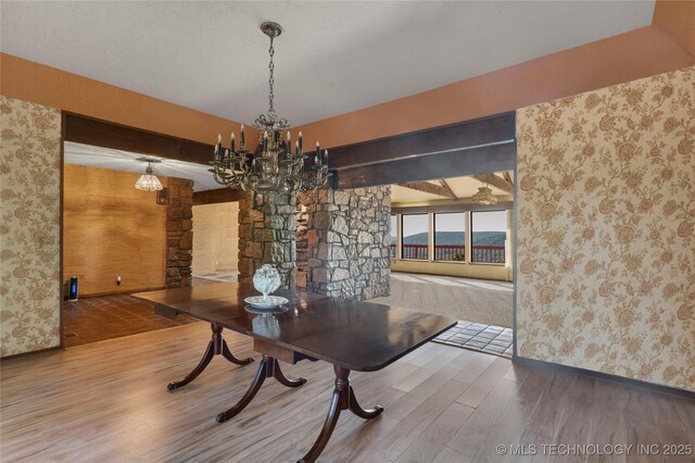 17304 E 176th St S, Bixby, OK 74008 - dining space with wallpapered walls, wood finished floors, a chandelier, and decorative columns
