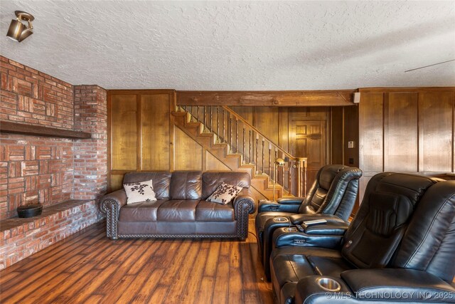 17304 E 176th St S, Bixby, OK 74008 - living room with a textured ceiling, wood finished floors, brick wall, wood walls, and stairs