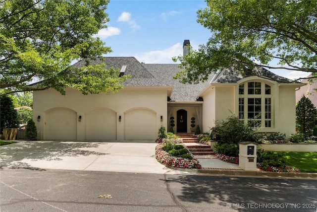 2524 E 66th Pl, Tulsa, OK 74136 - french provincial home featuring stucco siding, a garage, concrete driveway, a chimney, and a shingled roof