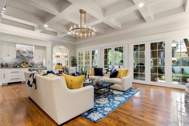 2524 E 66th Pl, Tulsa, OK 74136 - living room featuring arched walkways, healthy amount of natural light, coffered ceiling, a chandelier, and beamed ceiling