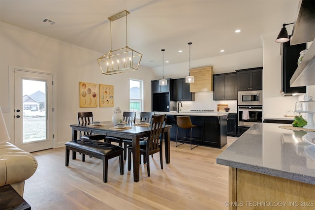 7117 E Queens St, Broken Arrow, OK 74014 - dining space featuring light wood-style floors, recessed lighting, a chandelier, and crown molding