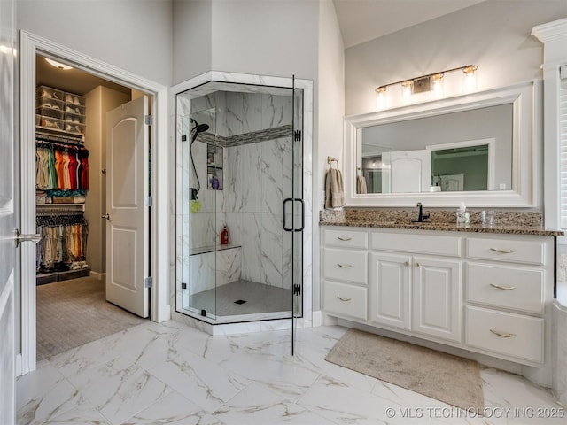 5509 E 121st Pl S, Tulsa, OK 74008 - bathroom with a marble finish shower, vanity, a walk in closet, and marble look tile flooring