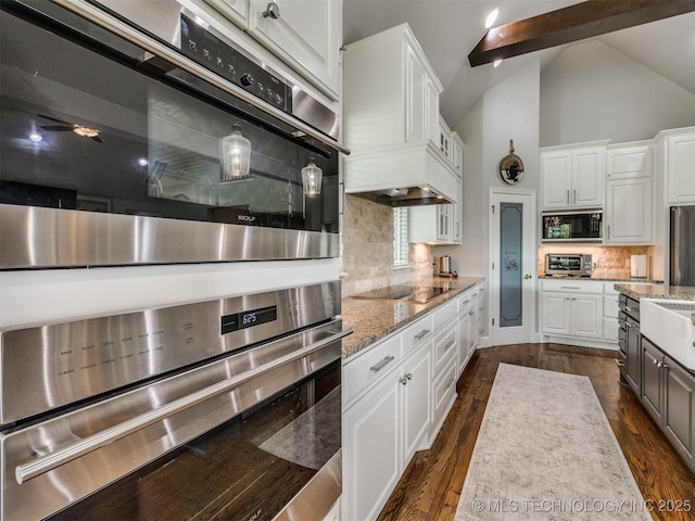 5509 E 121st Pl S, Tulsa, OK 74008 - kitchen with black appliances, white cabinetry, tasteful backsplash, light stone counters, and high vaulted ceiling