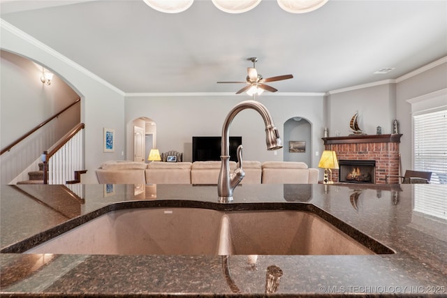 6904 S Chestnut Ave, Broken Arrow, OK 74011 - kitchen featuring a ceiling fan, a fireplace, crown molding, dark stone countertops, and open floor plan