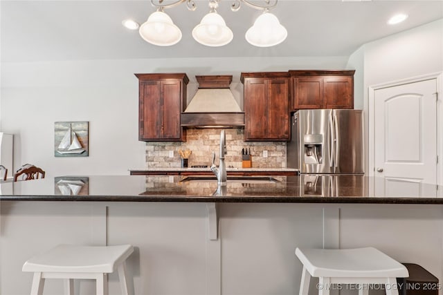 6904 S Chestnut Ave, Broken Arrow, OK 74011 - kitchen featuring stainless steel fridge, custom range hood, backsplash, a breakfast bar area, and recessed lighting