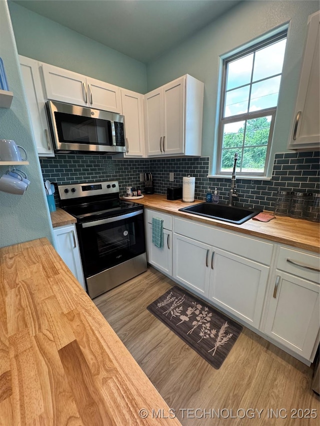 33455 State Highway 82, Cookson, OK 74427 - kitchen with appliances with stainless steel finishes, butcher block countertops, light wood-style flooring, and white cabinets