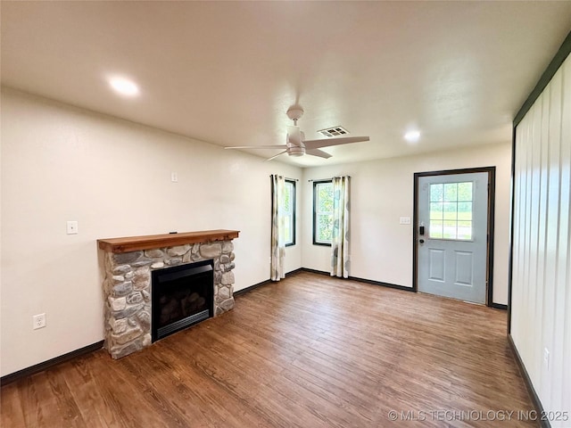 206 S 2nd St, Eufaula, OK 74432 - unfurnished living room with a stone fireplace, wood finished floors, ceiling fan, and recessed lighting