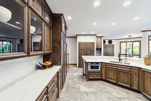 2151 E 27th St, Tulsa, OK 74114 - kitchen with ornamental molding, recessed lighting, backsplash, dark brown cabinets, and light stone countertops