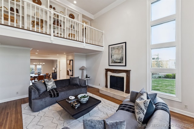 2151 E 27th St, Tulsa, OK 74114 - living area with a towering ceiling, a chandelier, a premium fireplace, ornamental molding, and wood finished floors