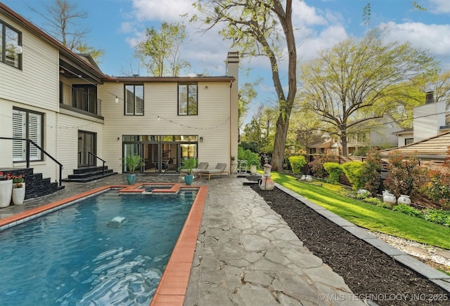 2151 E 27th St, Tulsa, OK 74114 - back of property with a patio, a chimney, and a pool with connected hot tub