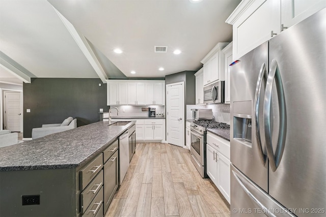 8035 Tims Ln, Claremore, OK 74019 - kitchen featuring appliances with stainless steel finishes, white cabinetry, recessed lighting, light wood-style floors, and backsplash