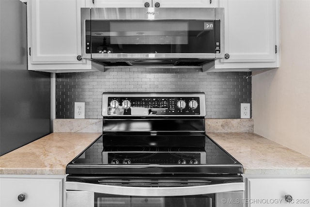2807 E 90th St Unit 4, Tulsa, OK 74137 - kitchen with appliances with stainless steel finishes, decorative backsplash, and white cabinetry