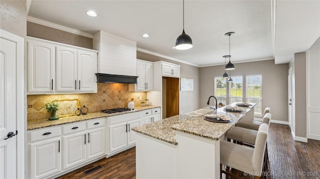 9198 E 120th St S, Bixby, OK 74008 - kitchen featuring dark wood finished floors, light stone countertops, tasteful backsplash, white cabinets, and stainless steel gas stovetop