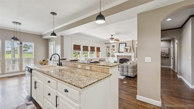 9198 E 120th St S, Bixby, OK 74008 - kitchen featuring an island with sink, arched walkways, ornamental molding, a ceiling fan, and dark wood-style floors