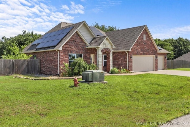 23609 E 135th St, Coweta, OK 74429 - view of front facade with concrete driveway, roof mounted solar panels, an attached garage, and brick siding