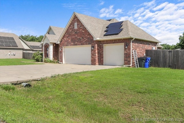 23609 E 135th St, Coweta, OK 74429 - view of front of house with a shingled roof, driveway, brick siding, roof mounted solar panels, and an attached garage