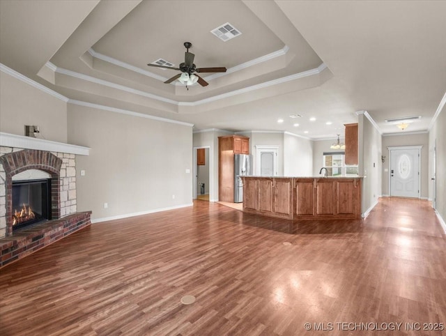 23609 E 135th St, Coweta, OK 74429 - unfurnished living room with a raised ceiling, a ceiling fan, wood finished floors, ornamental molding, and a fireplace