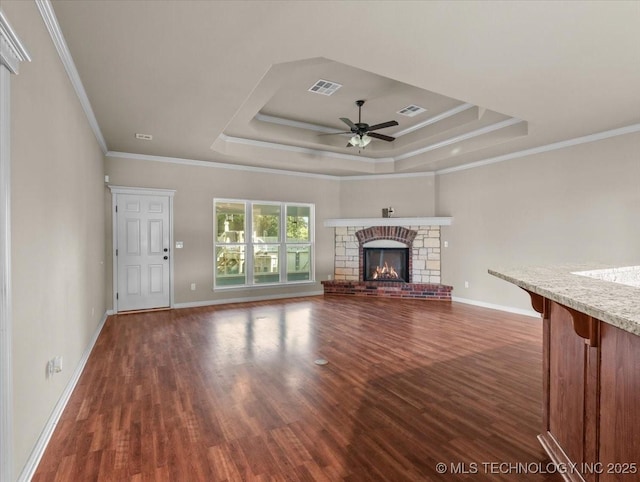 23609 E 135th St, Coweta, OK 74429 - unfurnished living room featuring a raised ceiling, dark wood-style floors, ceiling fan, ornamental molding, and a glass covered fireplace