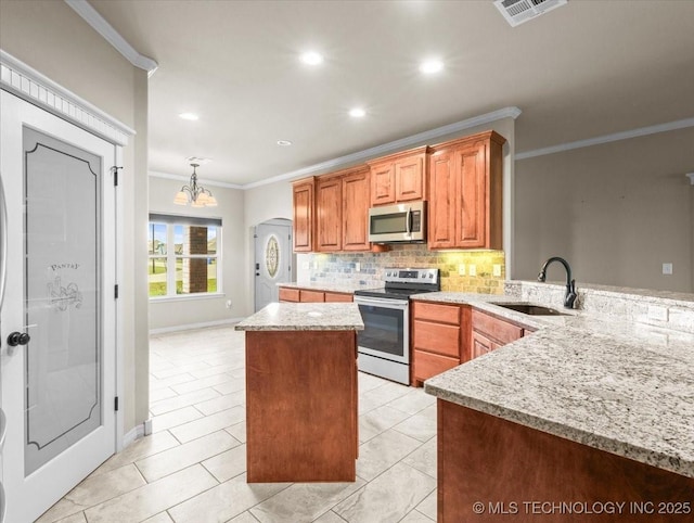 23609 E 135th St, Coweta, OK 74429 - kitchen featuring appliances with stainless steel finishes, crown molding, a kitchen island, backsplash, and light stone countertops