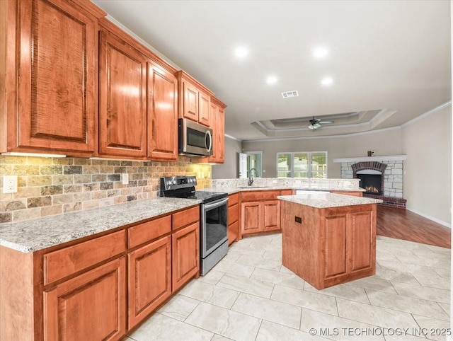 23609 E 135th St, Coweta, OK 74429 - kitchen featuring stainless steel appliances, ornamental molding, a raised ceiling, tasteful backsplash, and a ceiling fan