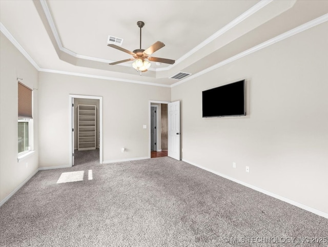 23609 E 135th St, Coweta, OK 74429 - unfurnished bedroom with a raised ceiling, ornamental molding, carpet, a ceiling fan, and a walk in closet