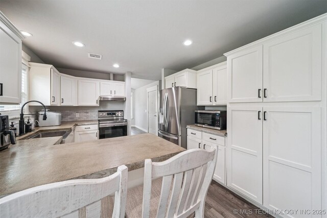 12929 N Sheridan Rd, Collinsville, OK 74021 - kitchen featuring stainless steel appliances, recessed lighting, dark wood-style flooring, light countertops, and white cabinetry