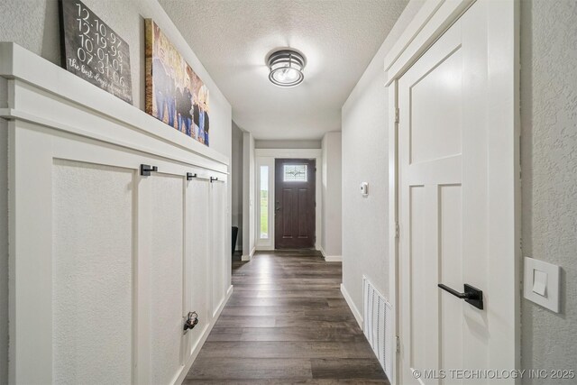 12929 N Sheridan Rd, Collinsville, OK 74021 - entryway with dark wood-style flooring, a textured wall, and a textured ceiling