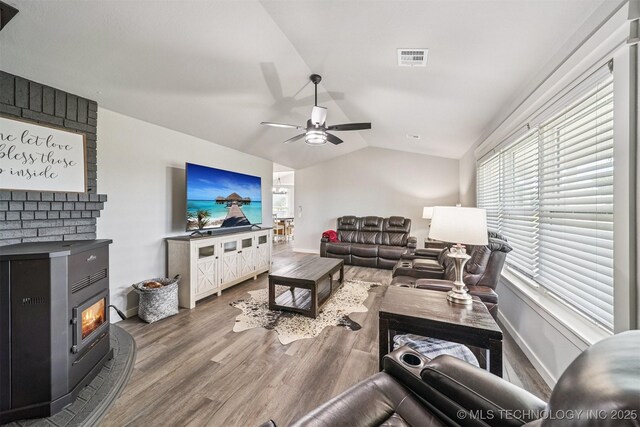 12929 N Sheridan Rd, Collinsville, OK 74021 - living room featuring wood finished floors, ceiling fan, lofted ceiling, and a wood stove