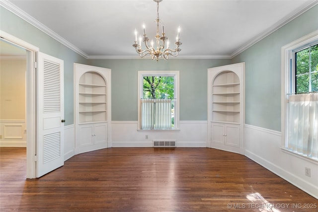 321 E 29th Pl, Tulsa, OK 74114 - unfurnished dining area with built in shelves, a chandelier, wood finished floors, a wainscoted wall, and crown molding
