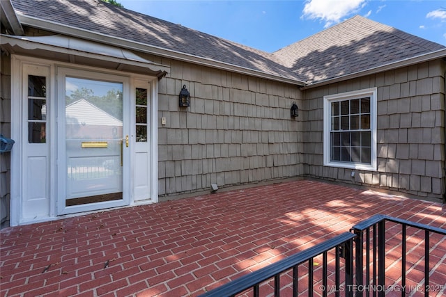 321 E 29th Pl, Tulsa, OK 74114 - property entrance featuring roof with shingles and a patio area