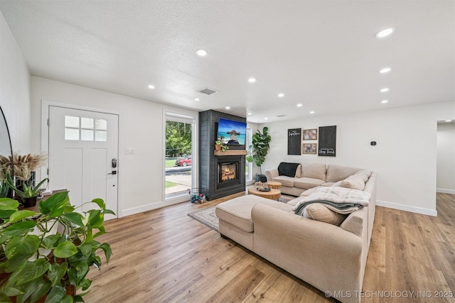 210 NW 4th St, Checotah, OK 74426 - living area featuring light wood-style flooring, a large fireplace, and recessed lighting