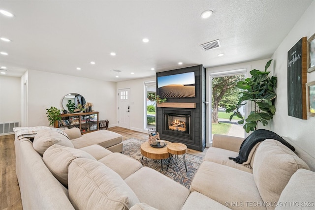 210 NW 4th St, Checotah, OK 74426 - living area featuring light wood-style flooring, plenty of natural light, recessed lighting, and a large fireplace