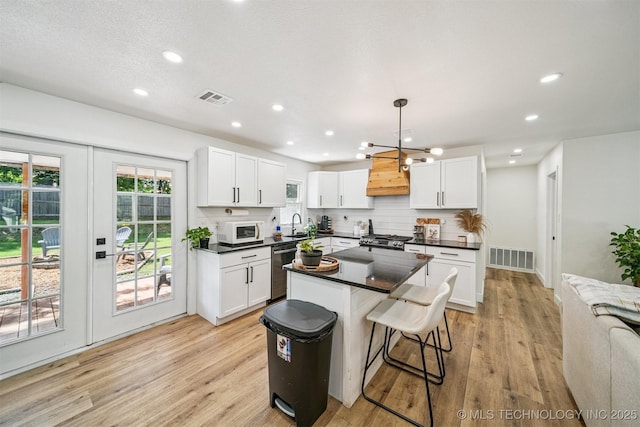 210 NW 4th St, Checotah, OK 74426 - kitchen with white microwave, dark countertops, dishwasher, white cabinetry, and recessed lighting