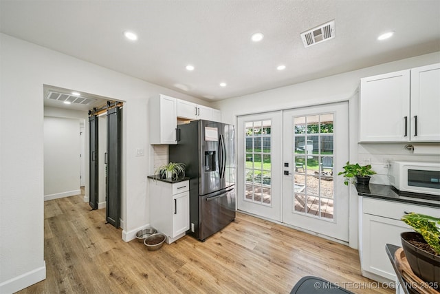 210 NW 4th St, Checotah, OK 74426 - kitchen with stainless steel fridge, white microwave, french doors, dark countertops, and recessed lighting
