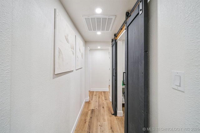 210 NW 4th St, Checotah, OK 74426 - hallway featuring a barn door, light wood-type flooring, and recessed lighting