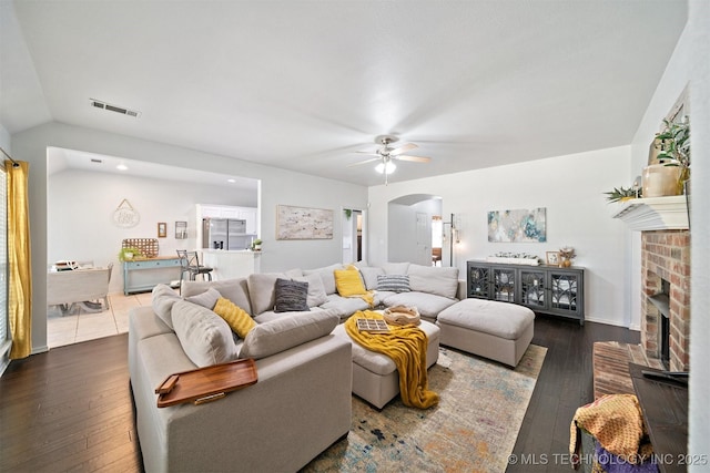 304 S 63rd St, Broken Arrow, OK 74014 - living room with arched walkways, a ceiling fan, a brick fireplace, dark wood-style flooring, and lofted ceiling