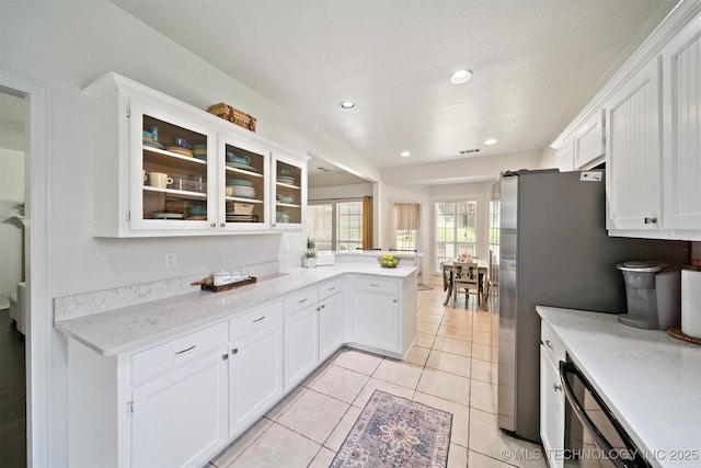 304 S 63rd St, Broken Arrow, OK 74014 - kitchen with a peninsula, white cabinetry, glass insert cabinets, light tile patterned floors, and light stone counters