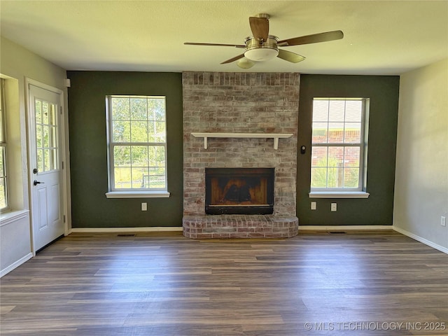 3610 Magnolia Dr, Sand Springs, OK 74063 - unfurnished living room featuring wood finished floors, plenty of natural light, ceiling fan, and a fireplace