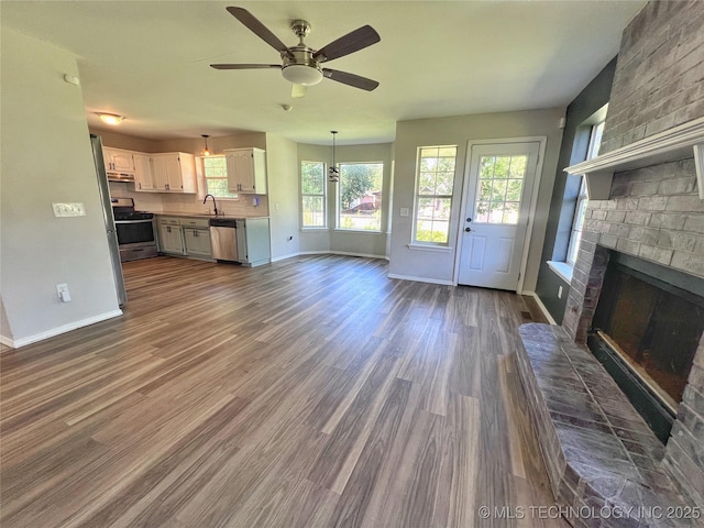 3610 Magnolia Dr, Sand Springs, OK 74063 - unfurnished living room with a brick fireplace, ceiling fan, and dark wood finished floors