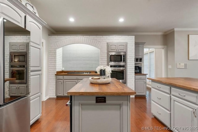 8766 Haskell Dr, Broken Arrow, OK 74014 - kitchen featuring wooden counters, stainless steel appliances, dark wood-style flooring, crown molding, and recessed lighting