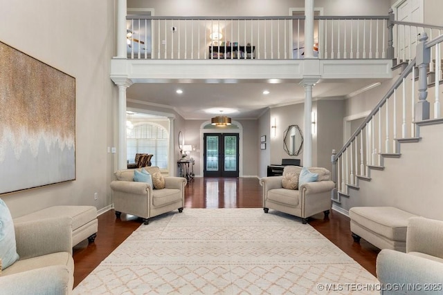 8766 Haskell Dr, Broken Arrow, OK 74014 - living area featuring dark wood-type flooring, stairs, ornamental molding, a high ceiling, and french doors