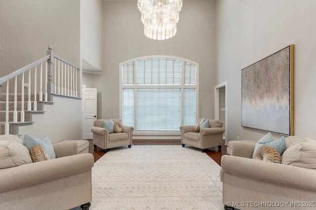 8766 Haskell Dr, Broken Arrow, OK 74014 - living room featuring a towering ceiling, a chandelier, and wood finished floors