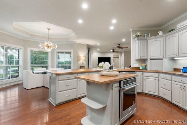 8766 Haskell Dr, Broken Arrow, OK 74014 - kitchen featuring wooden counters, stainless steel oven, a kitchen island, plenty of natural light, and crown molding