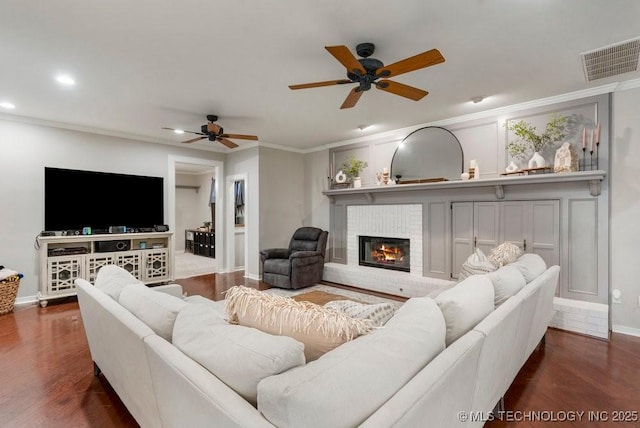 8766 Haskell Dr, Broken Arrow, OK 74014 - living room with ornamental molding, ceiling fan, dark wood-type flooring, a fireplace, and recessed lighting