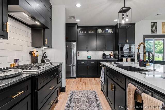 21933 E 101st Pl S, Broken Arrow, OK 74014 - kitchen with stainless steel appliances, extractor fan, dark stone counters, backsplash, and recessed lighting