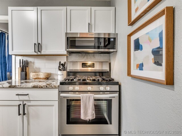 2016 W Easton St, Tulsa, OK 74127 - kitchen featuring stainless steel appliances, tasteful backsplash, white cabinetry, a textured wall, and light stone countertops