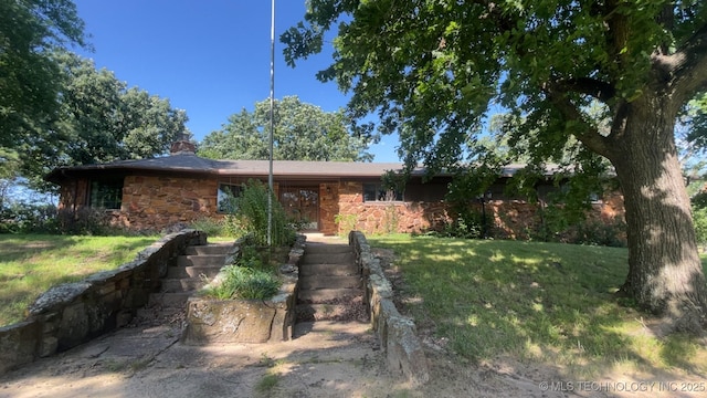1943 W 163rd St, Skiatook, OK 74070 - view of front of property featuring stone siding, a front lawn, and a chimney
