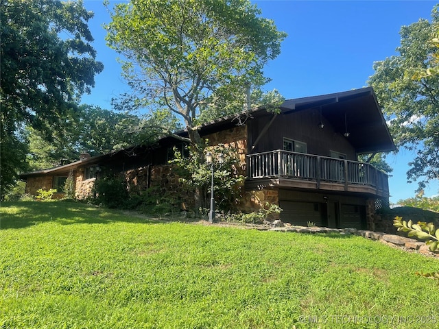 1943 W 163rd St, Skiatook, OK 74070 - rear view of house featuring stone siding, a lawn, a deck, and a garage