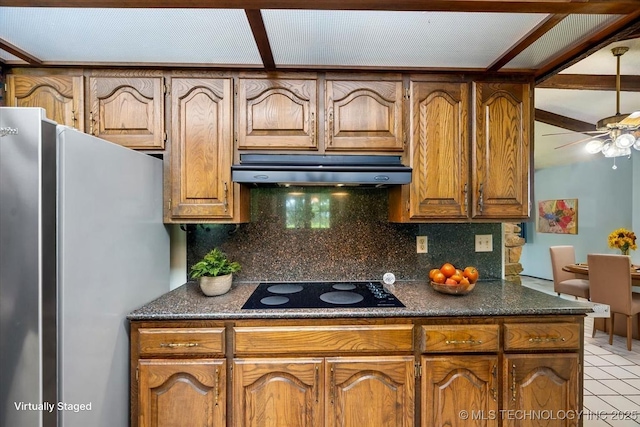 1943 W 163rd St, Skiatook, OK 74070 - kitchen with freestanding refrigerator, under cabinet range hood, black electric cooktop, tasteful backsplash, and a ceiling fan