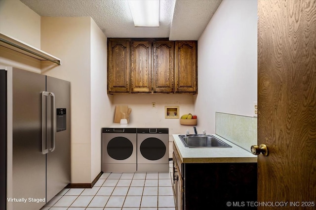 1943 W 163rd St, Skiatook, OK 74070 - washroom featuring cabinet space, washing machine and dryer, light tile patterned floors, and a textured ceiling
